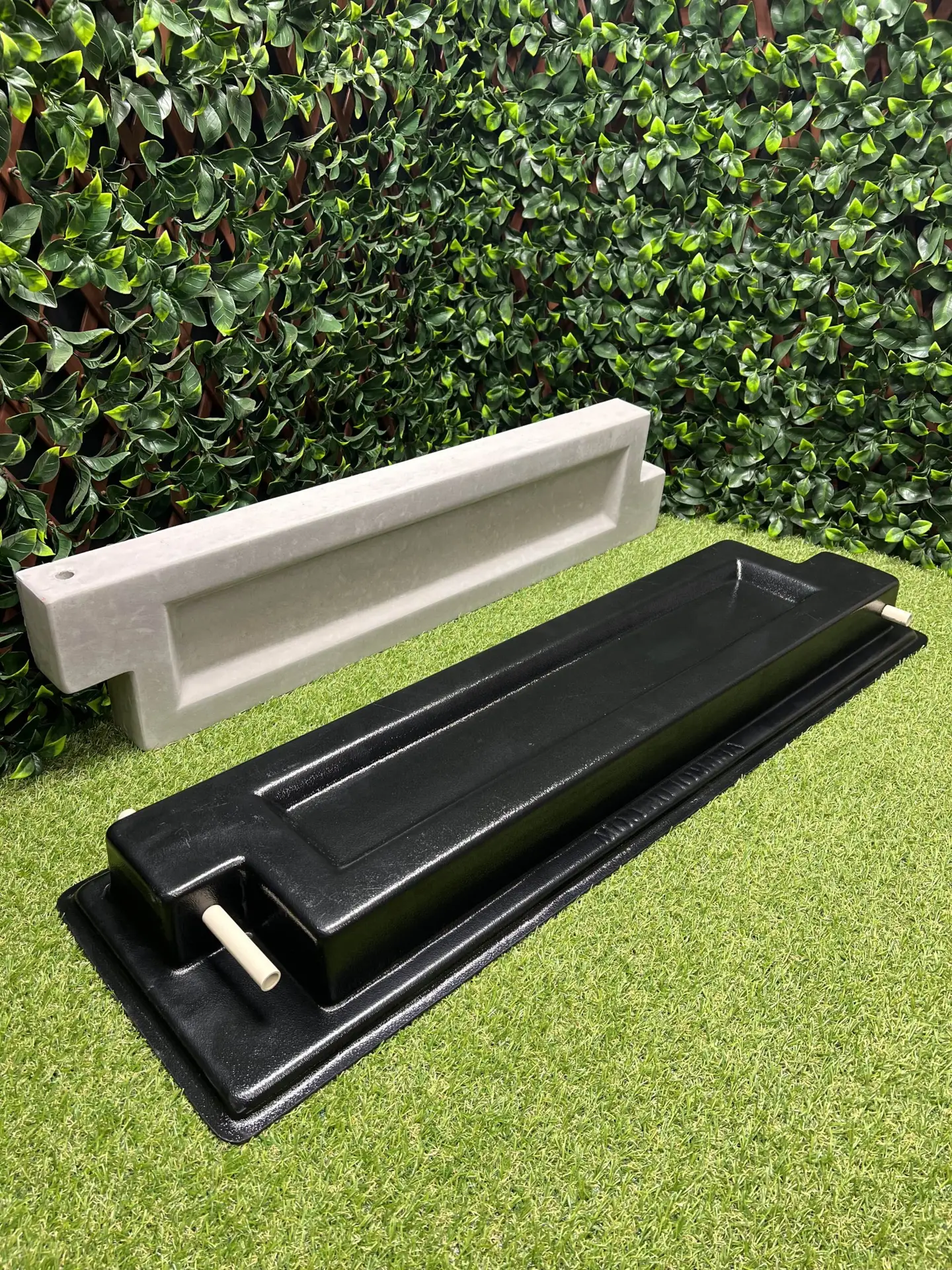 This is a picture of the bed block mold with a finished poured concrete block behind it.