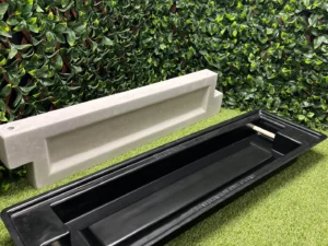 This is a picture of the bed block mold with a finished poured concrete block behind it.