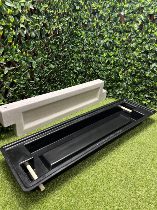 This is a picture of the bed block mold with a finished poured concrete block behind it.