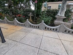Regal Arch concrete fence panels installed as a decorative garden border around landscaping and statues.