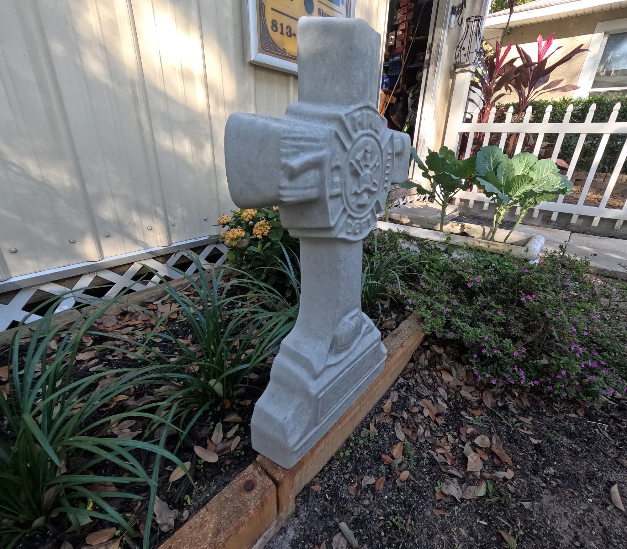 Finished Fireman Cross concrete memorial displayed in a garden setting